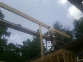 Carpenter setting a ridge beam over a new addition frame — Ice Dam Removal by Roofing Brothers in New Richmond